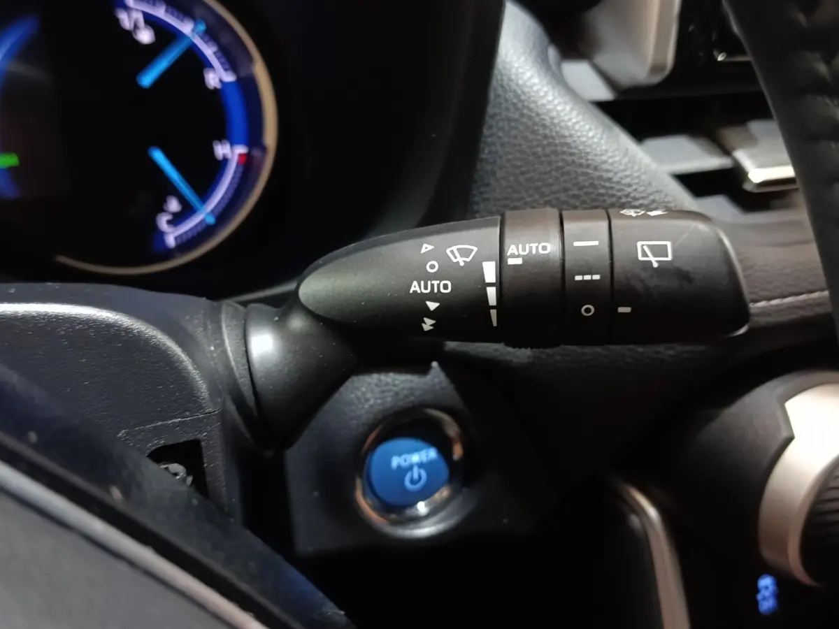 Gros plan sur la commande d’essuie-glace à gauche du volant dans l’habitacle noir du Toyota RAV4 hybride 2021.