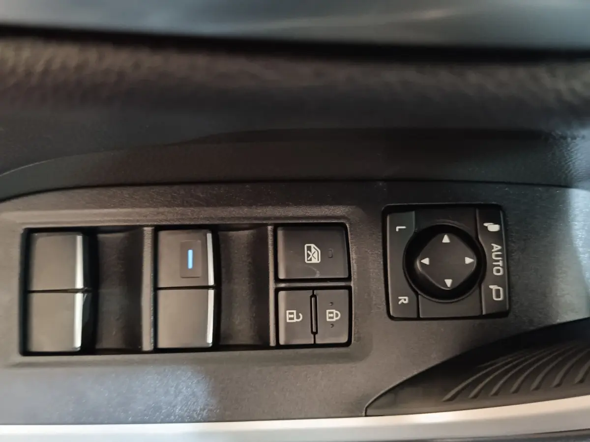 Gros plan sur les commandes des vitres et rétroviseurs côté conducteur du Toyota RAV4 hybride 2021, finition Dynamic.