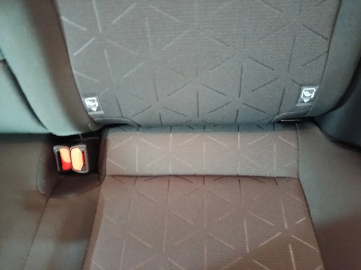 Gros plan sur la banquette arrière grise du Toyota RAV4 hybride, montrant les ceintures de sécurité et les fixations Isofix.