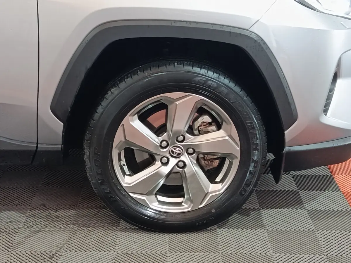 Gros plan sur la roue avant droite argentée du Toyota RAV4 Hybride 2021 avec carrosserie blanche visible.