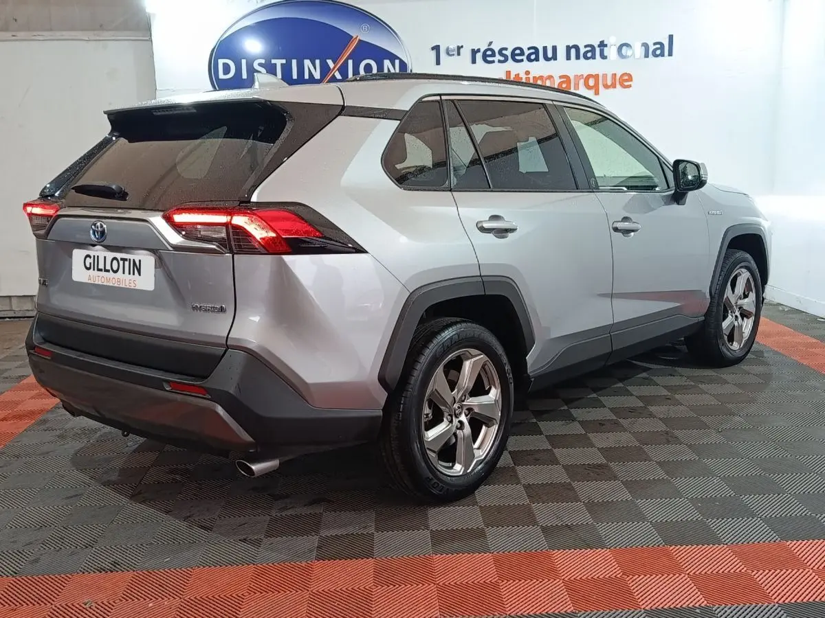 Vue 3/4 arrière droite du Toyota RAV4 hybride 2WD gris avec feux arrière LED et jantes alliage.