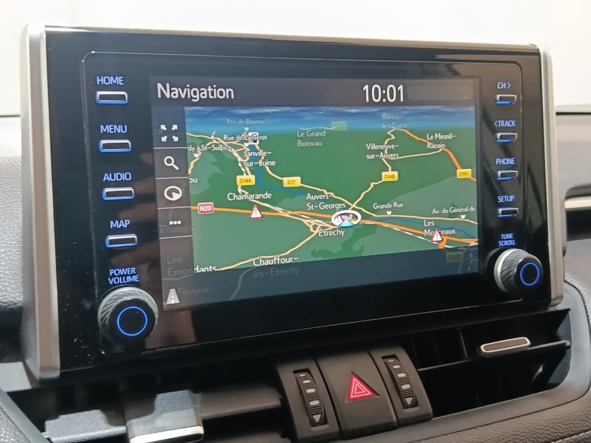 Écran tactile central du Toyota RAV4 Hybride 2021 affichant la navigation, avec boutons latéraux bleus et tableau de bord noir.