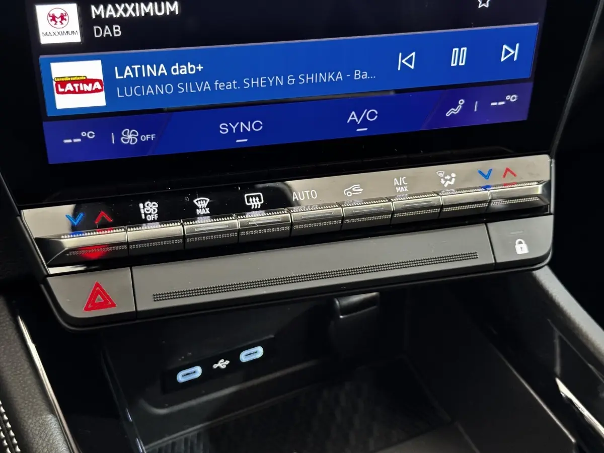 Gros plan sur la console centrale noire du Renault Espace 2025 avec écran tactile et commandes climatisation.