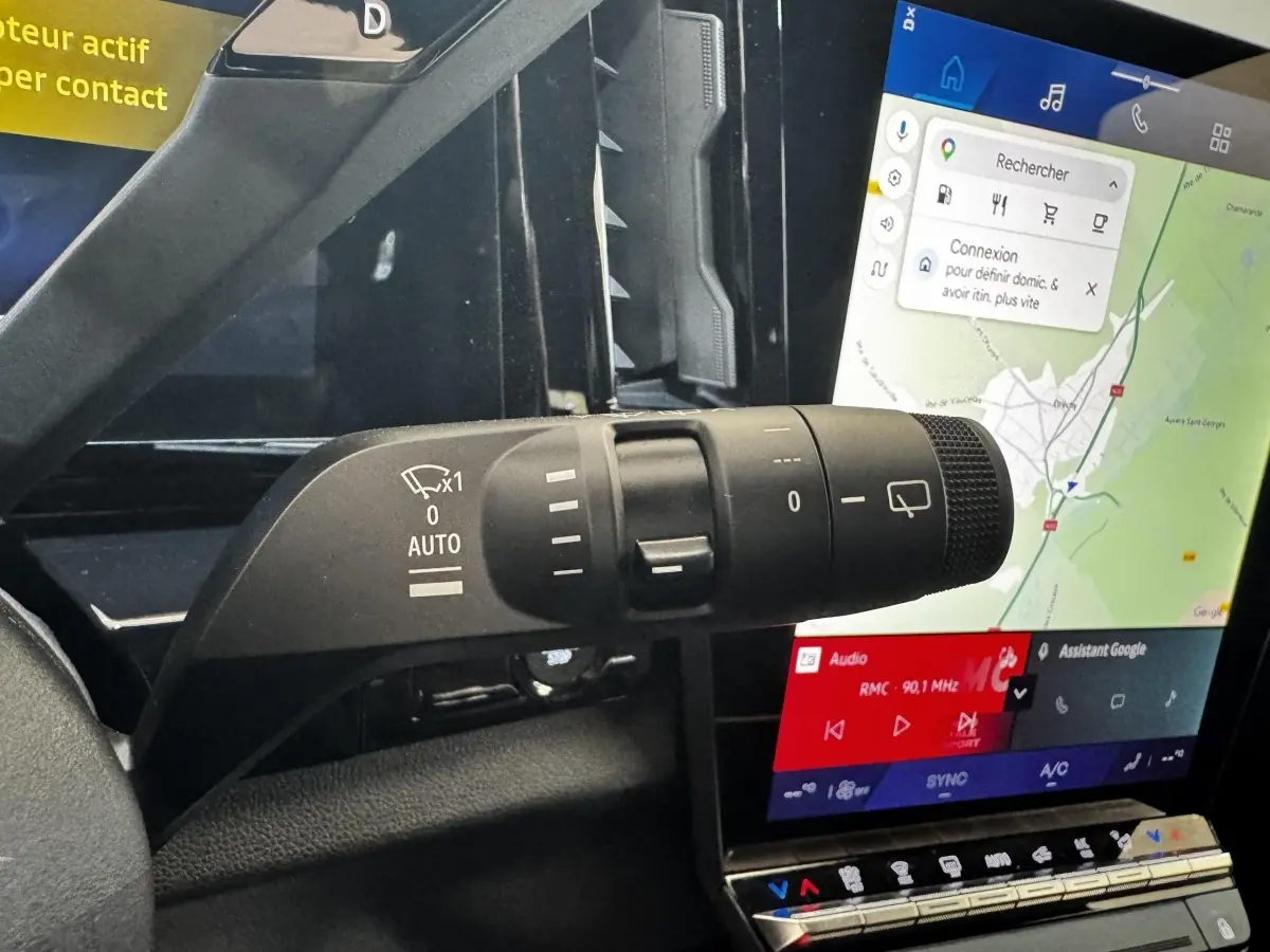 Gros plan sur la commande d’essuie-glace à gauche du volant, avec l’écran tactile central affichant la navigation du Renault Espace noir.