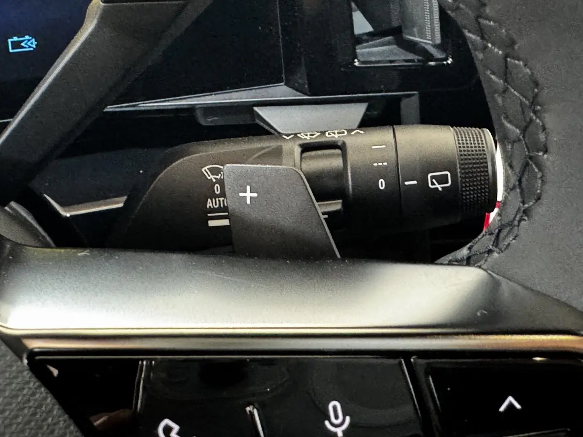 Gros plan sur la commande de clignotants et essuie-glaces du Renault Espace noir, intérieur avec volant cuir surpiqué.