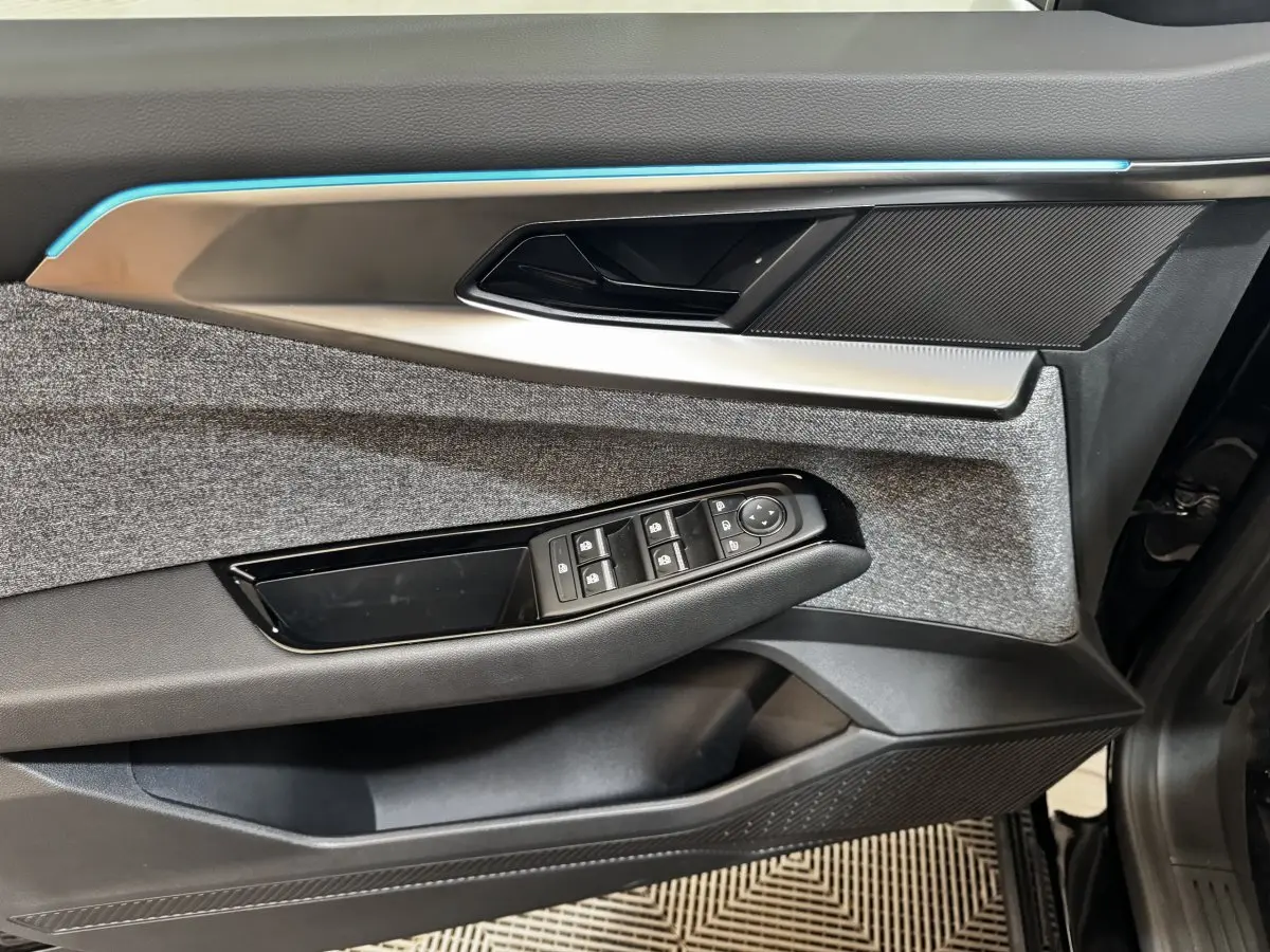 Détail de la porte avant gauche du Renault Espace 2025, avec commandes de vitres et insert textile gris.