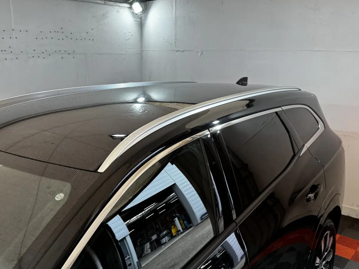 Vue en plongée du côté gauche arrière du Renault Espace noir avec rails de toit chromés et vitres teintées.