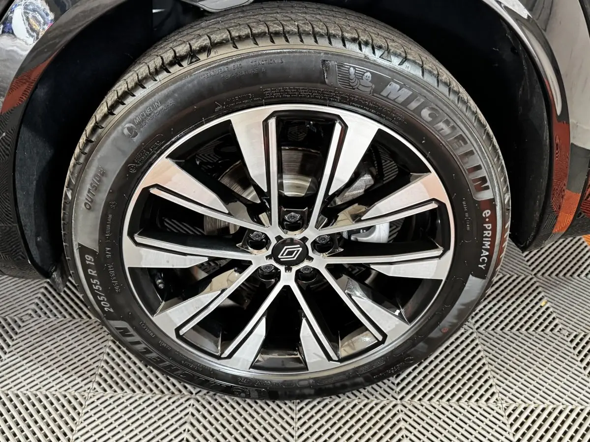 Gros plan sur la roue avant droite noire du Renault Espace 2025 avec jante alliage bicolore et pneu Michelin.