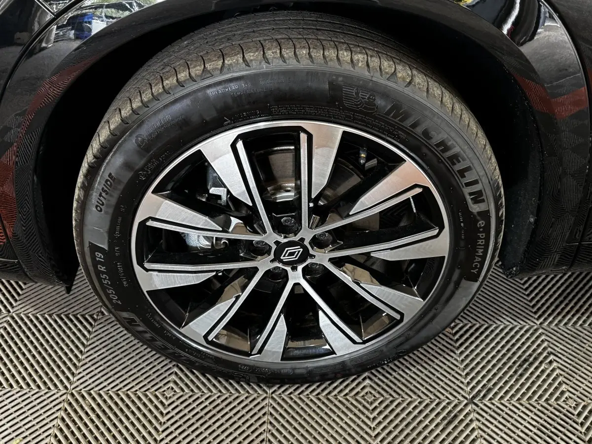 Gros plan sur la roue avant droite noire d’un Renault Espace 2025 avec jante alliage bicolore et pneu Michelin.