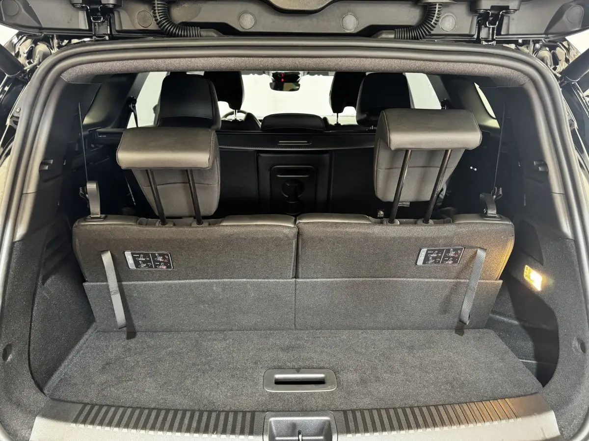 Vue intérieure du coffre arrière du Renault Espace noir 2025 avec sièges rabattables en position verticale.