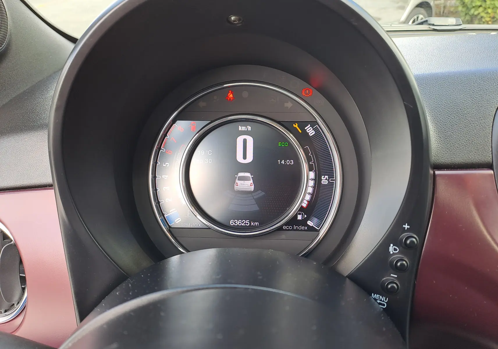 Vue rapprochée du tableau de bord de la Fiat 500 Opera Bordeaux, affichant le compteur digital et les voyants allumés.