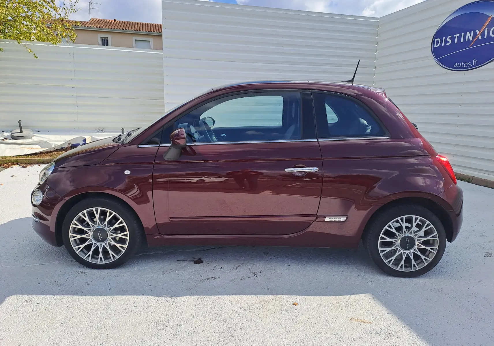Profil côté gauche d'une Fiat 500 2020 en couleur Opera Bordeaux Métal avec jantes alliage et poignées chromées.