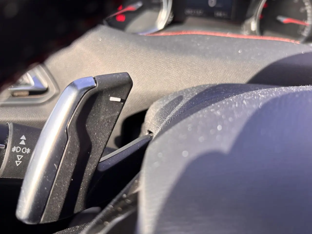 Gros plan sur la palette de changement de vitesse en aluminium à droite du volant d'une Peugeot 308 GT Line rouge foncé.