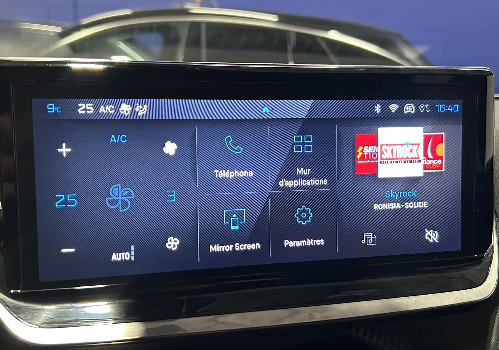 Écran tactile central du Peugeot 2008 gris 2025 affichant la climatisation, téléphone, applications et radio Skyrock.