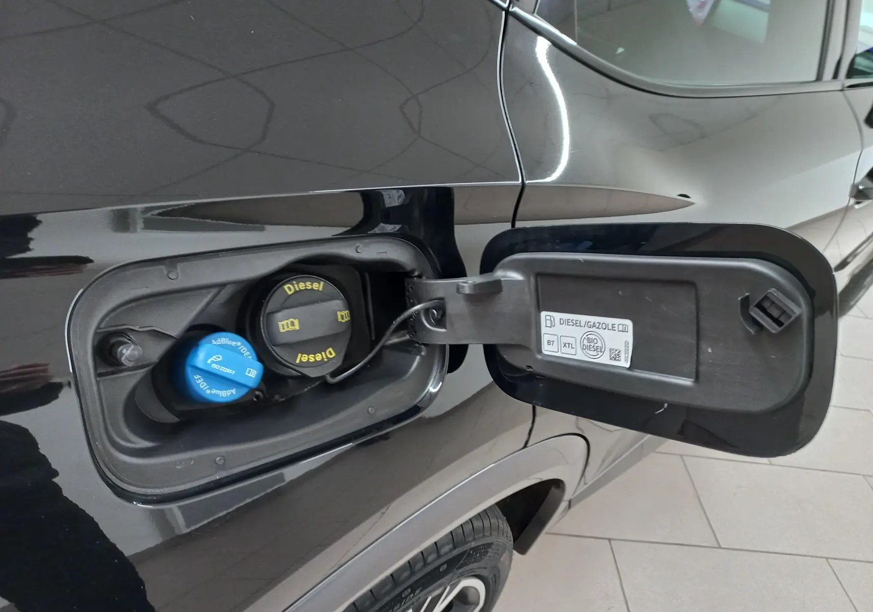 Gros plan sur la trappe à carburant côté gauche du CUPRA Formentor noir minuit avec bouchons Diesel et AdBlue visibles.