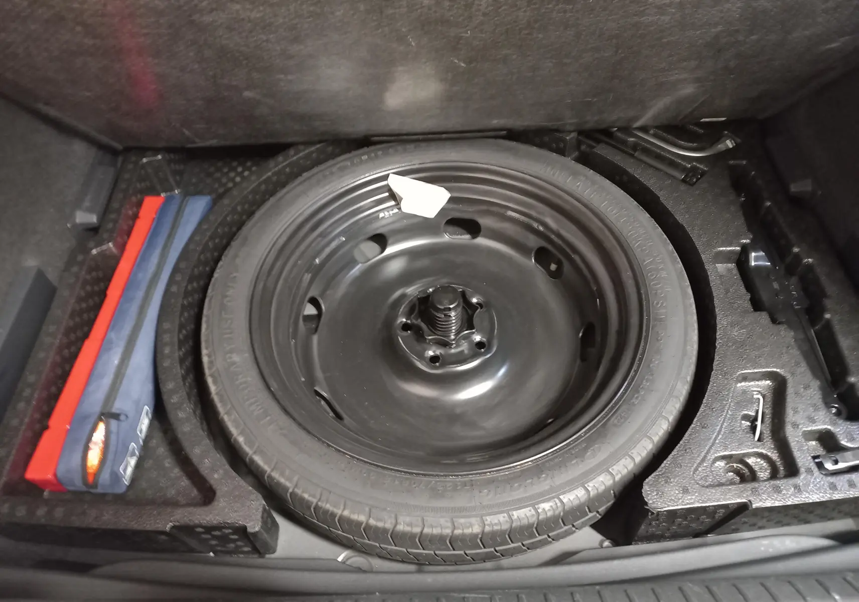 Vue rapprochée de la roue de secours noire dans le coffre d'une CUPRA Formentor 2023 Noir Minuit.