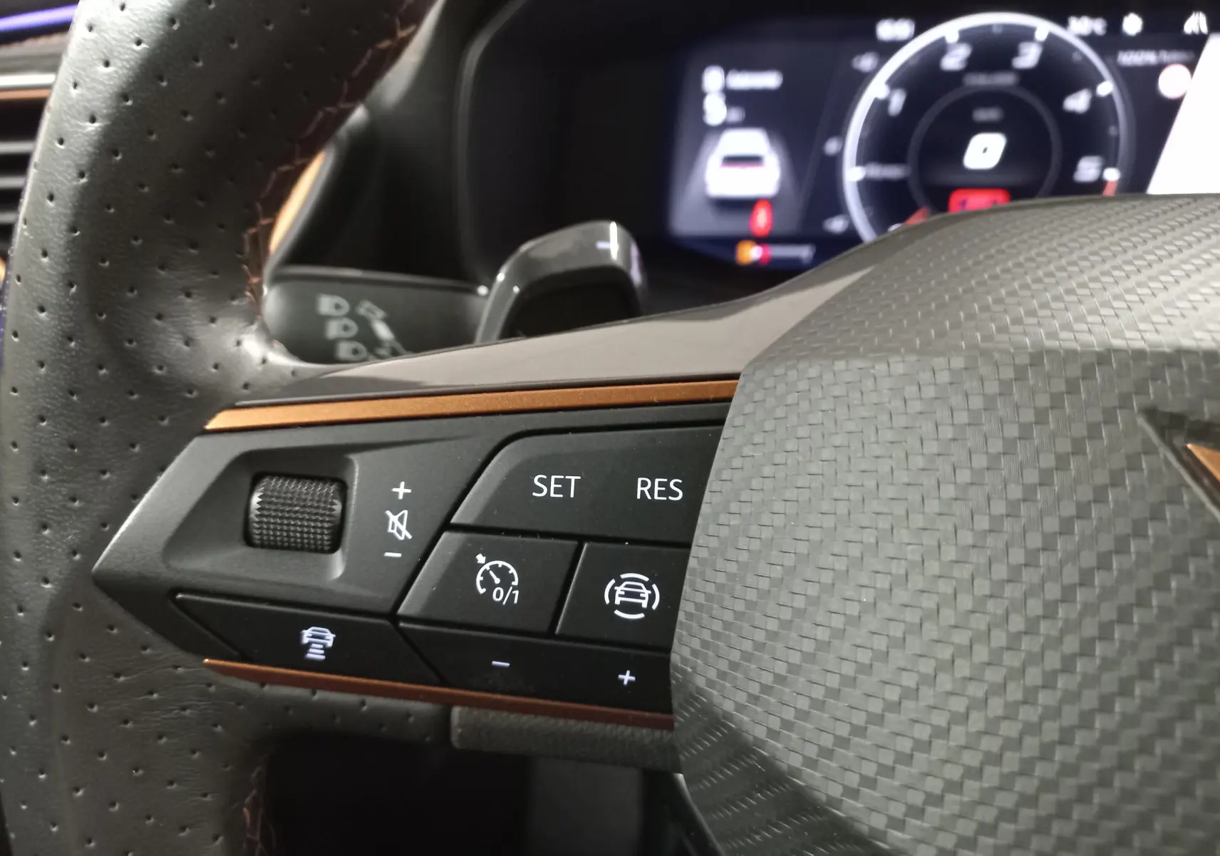 Gros plan sur la partie gauche du volant en cuir perforé du CUPRA Formentor 2023 avec commandes de régulateur et insert cuivre.