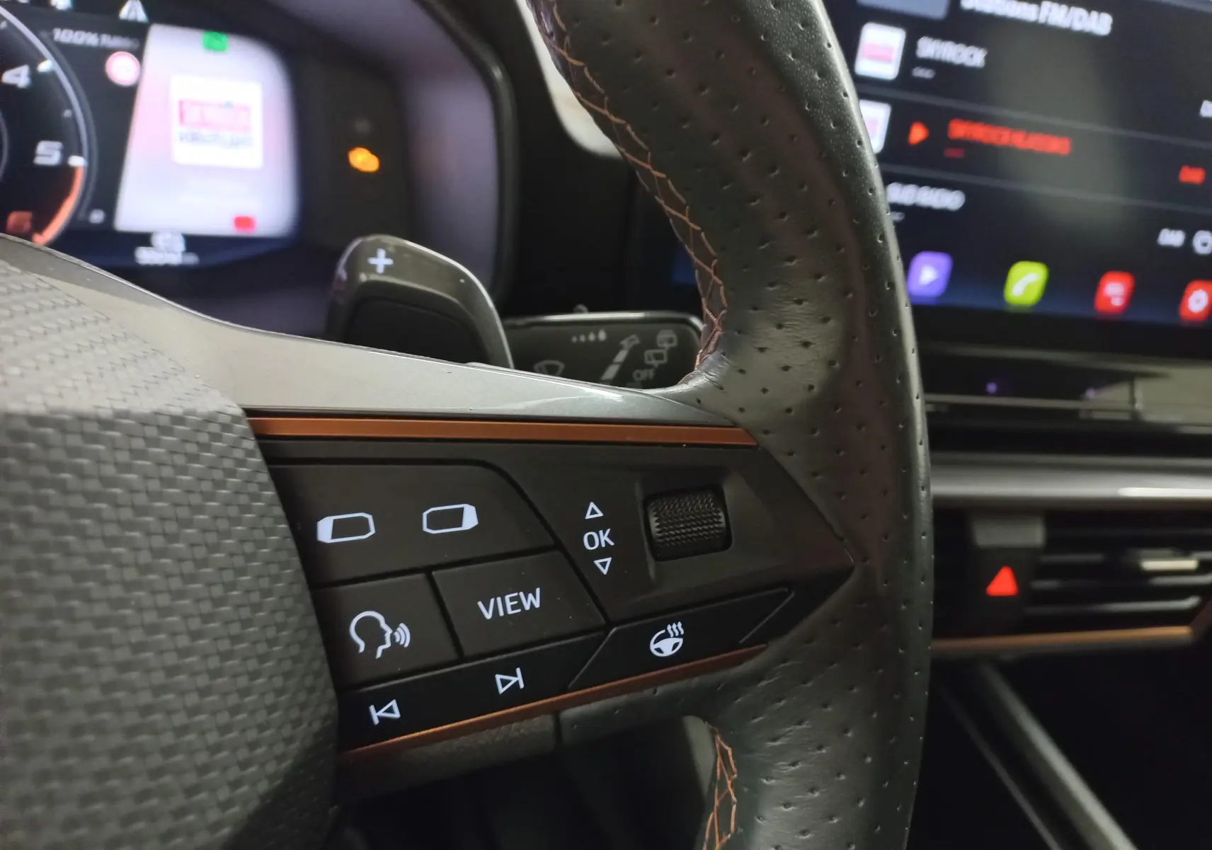 Gros plan sur le volant perforé noir avec commandes intégrées et éclairage d'ambiance intérieur du CUPRA Formentor 2023.