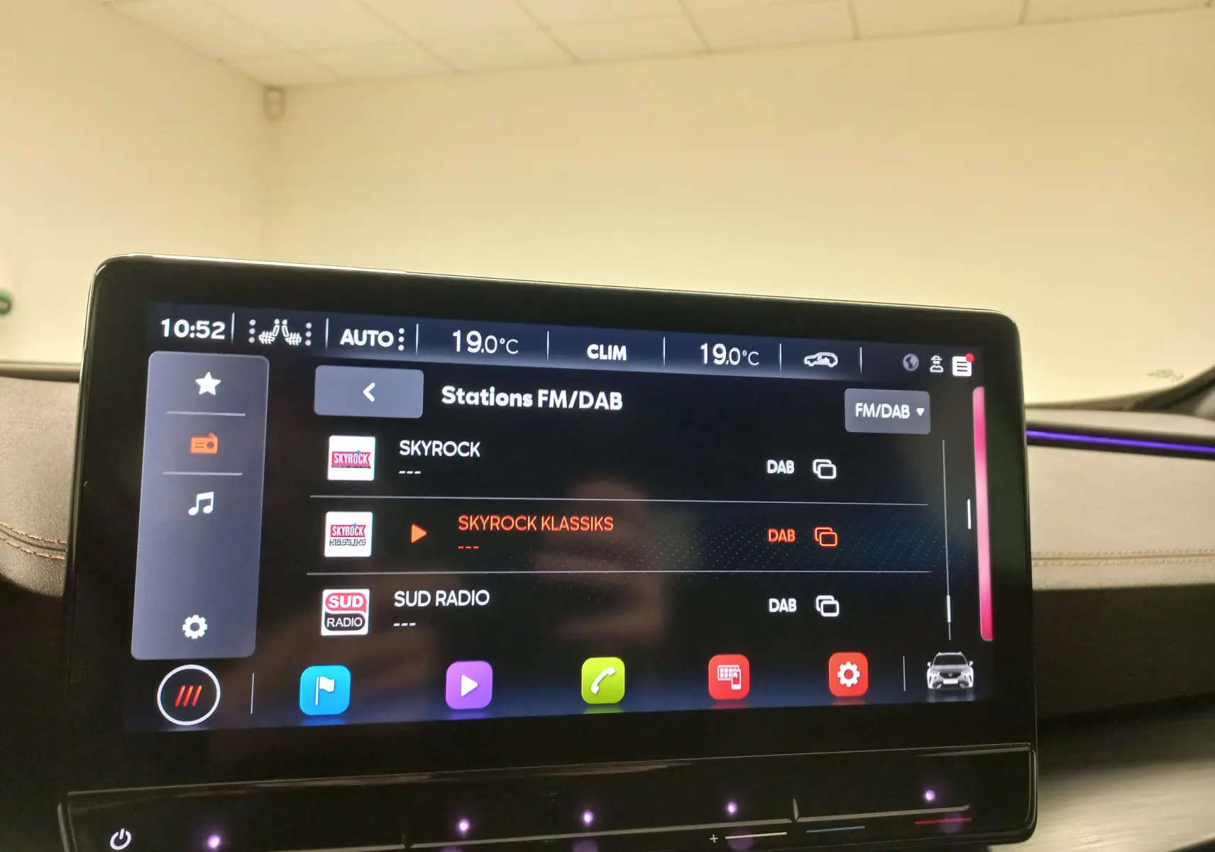 Intérieur du CUPRA Formentor 2023 avec écran tactile central et éclairage d'ambiance violet visible sur le tableau de bord.