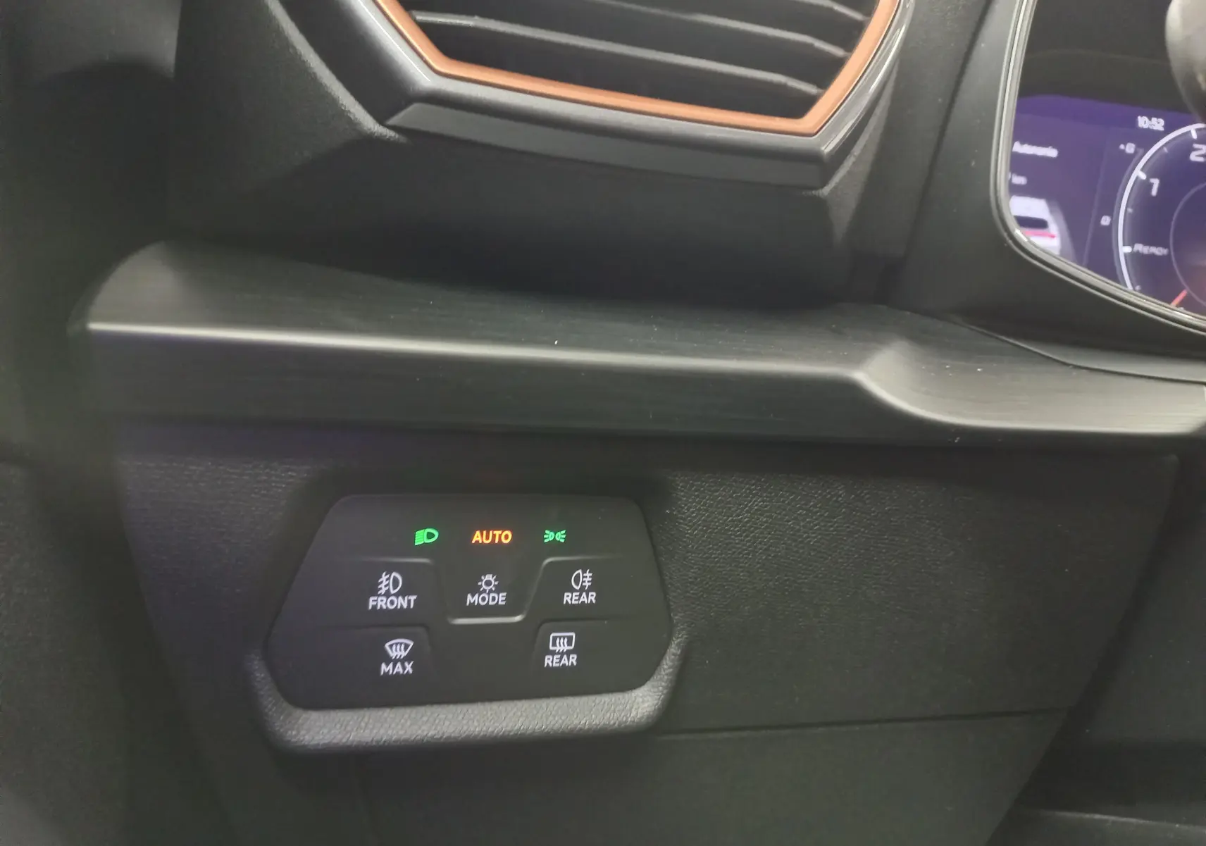 Vue intérieure rapprochée du tableau de bord du CUPRA Formentor 2023 avec éclairage d'ambiance orange et commandes des feux activées.