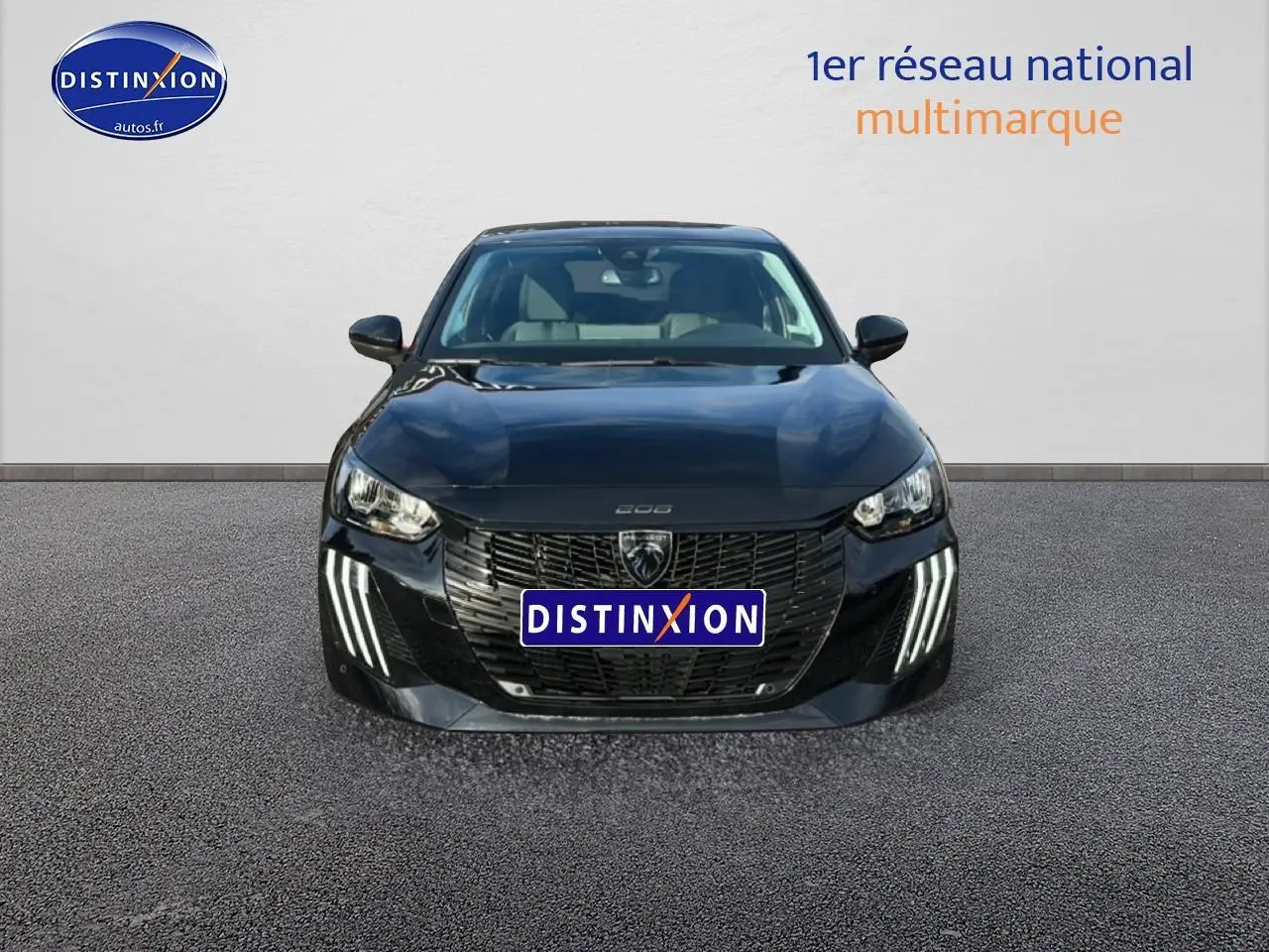 Vue frontale d'une Peugeot 208 noire 2024 avec phares LED et calandre imposante, sur fond neutre.