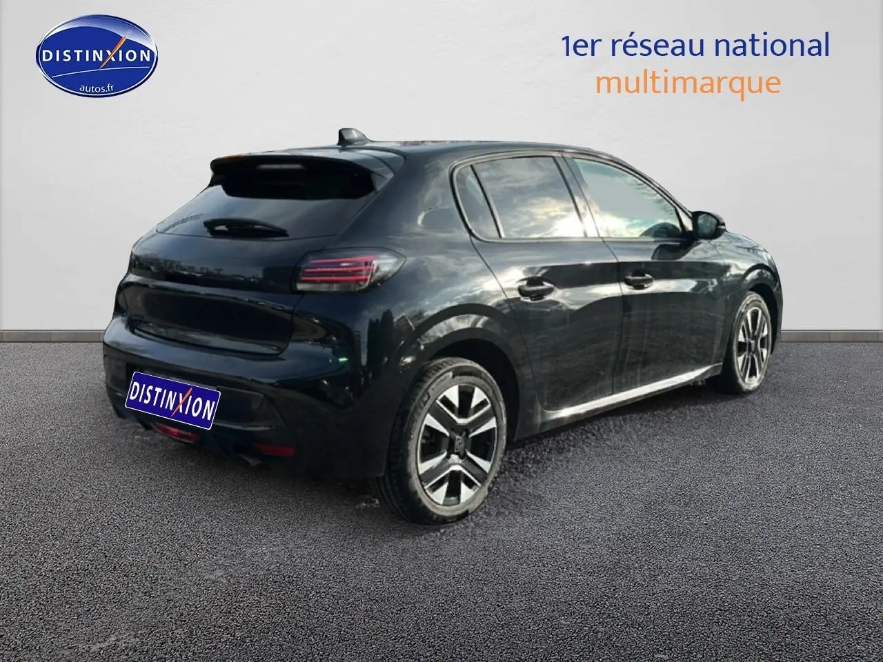 Vue 3/4 arrière droite d'une Peugeot 208 noire 2024 avec jantes alu et feux arrière LED.