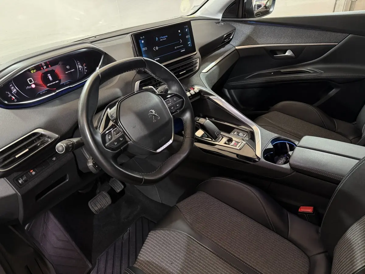 Intérieur noir du Peugeot 5008 2021 vu côté conducteur, avec volant cuir compact et écran tactile central.