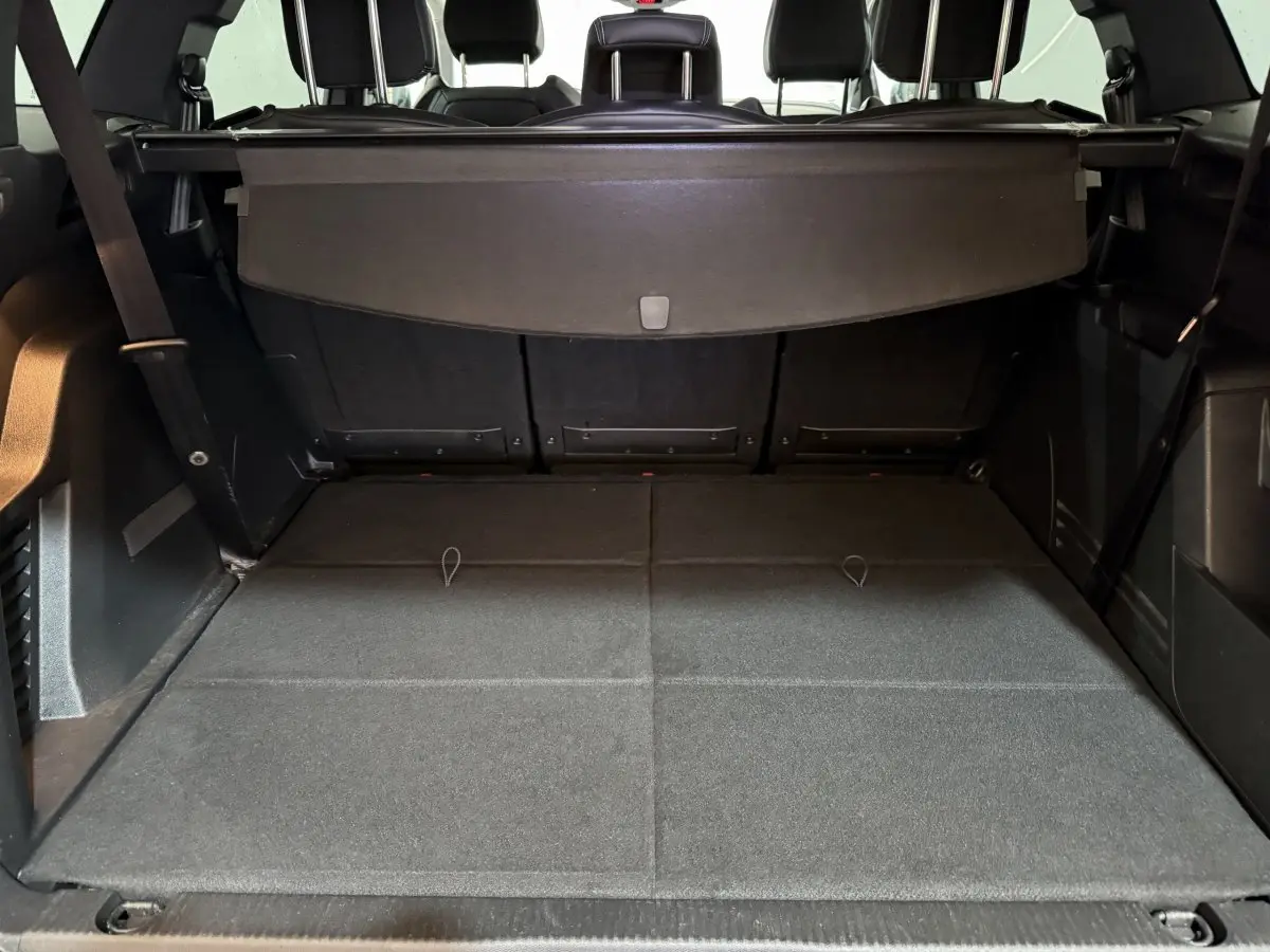 Coffre ouvert du Peugeot 5008 gris clair, vue de l'arrière montrant la grande capacité et la tablette cache-bagages.
