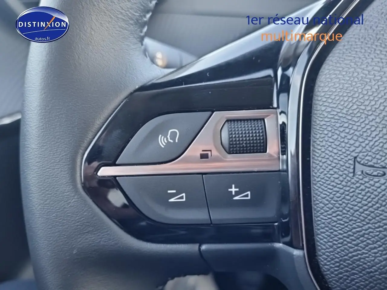 Gros plan sur les commandes audio au volant d'une Peugeot 208 1.2 100 Allure, finition noire brillante.