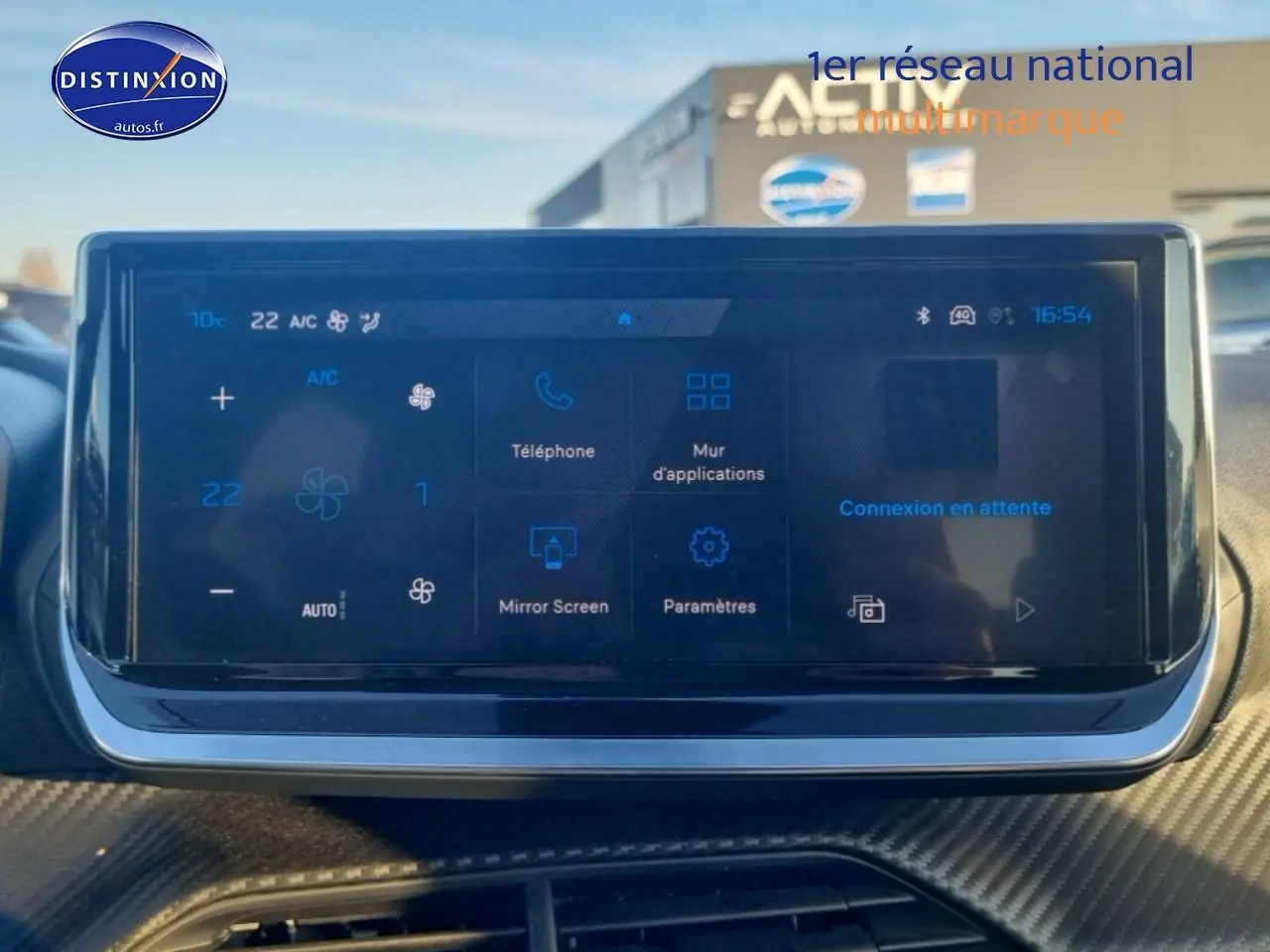 Écran tactile central affichant la climatisation et les applications, intérieur d'une Peugeot 208 gris artense.