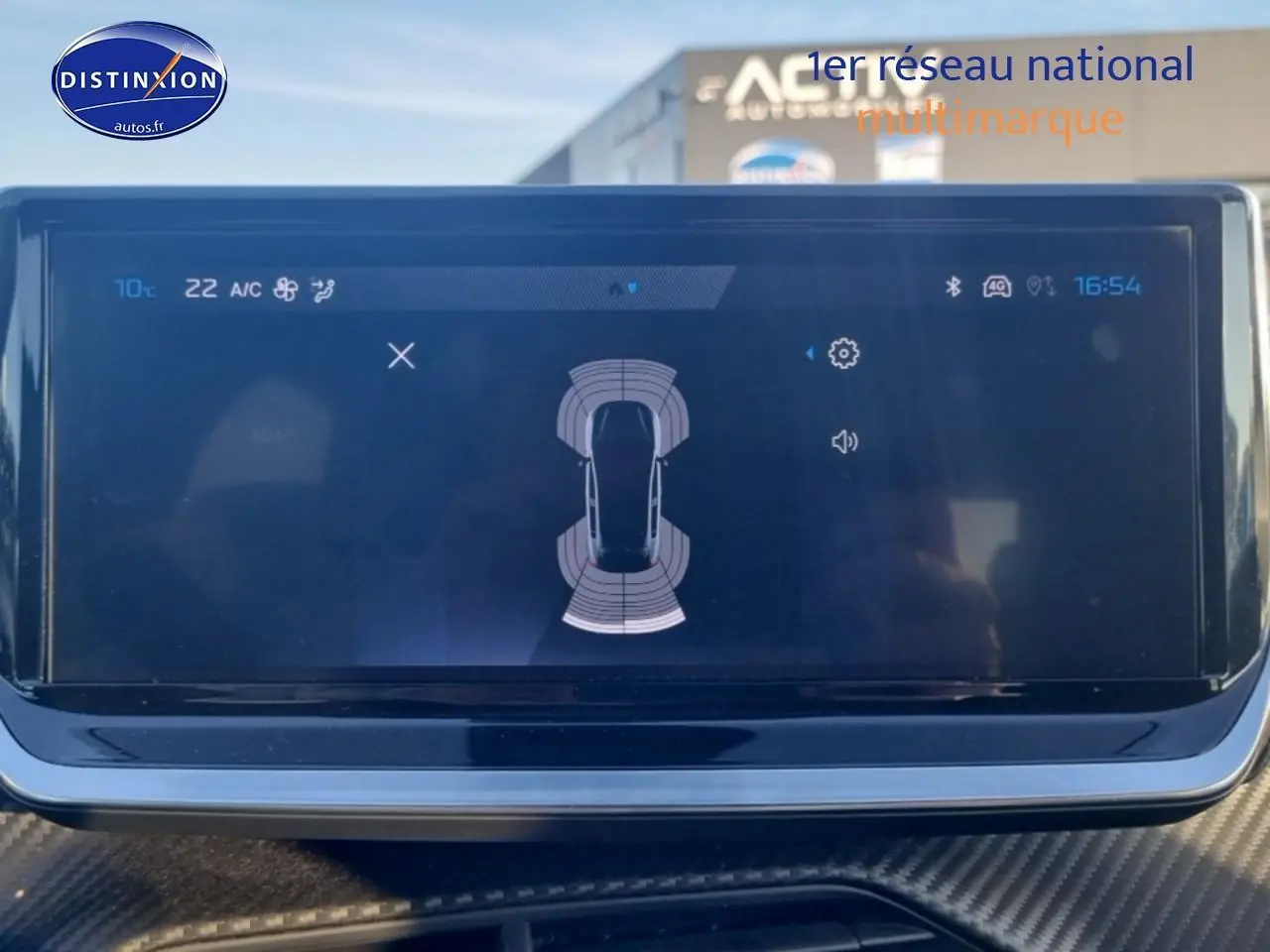 Écran tactile intérieur de la Peugeot 208 1.2 100 Allure affichant le système d'aide au stationnement.