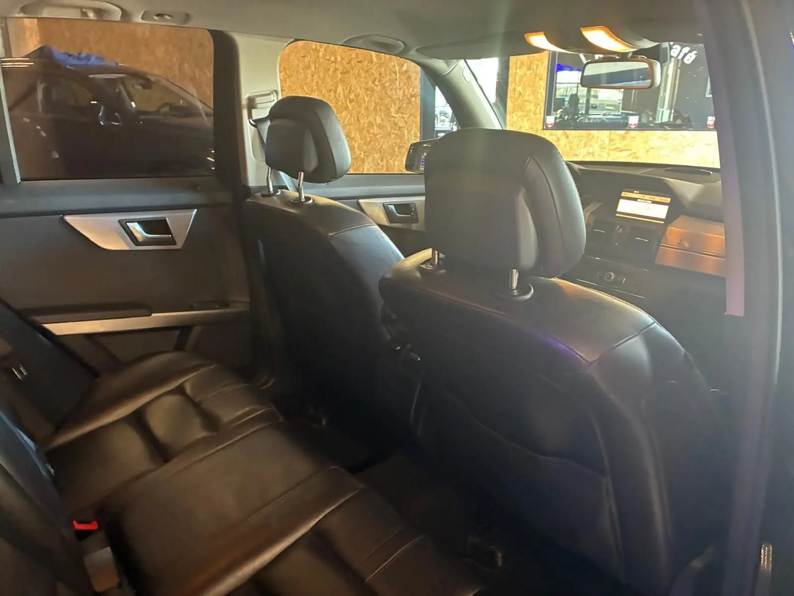 Vue intérieure arrière côté gauche du Mercedes GLK noir de 2012 avec sièges en cuir noir et tableau de bord visible.