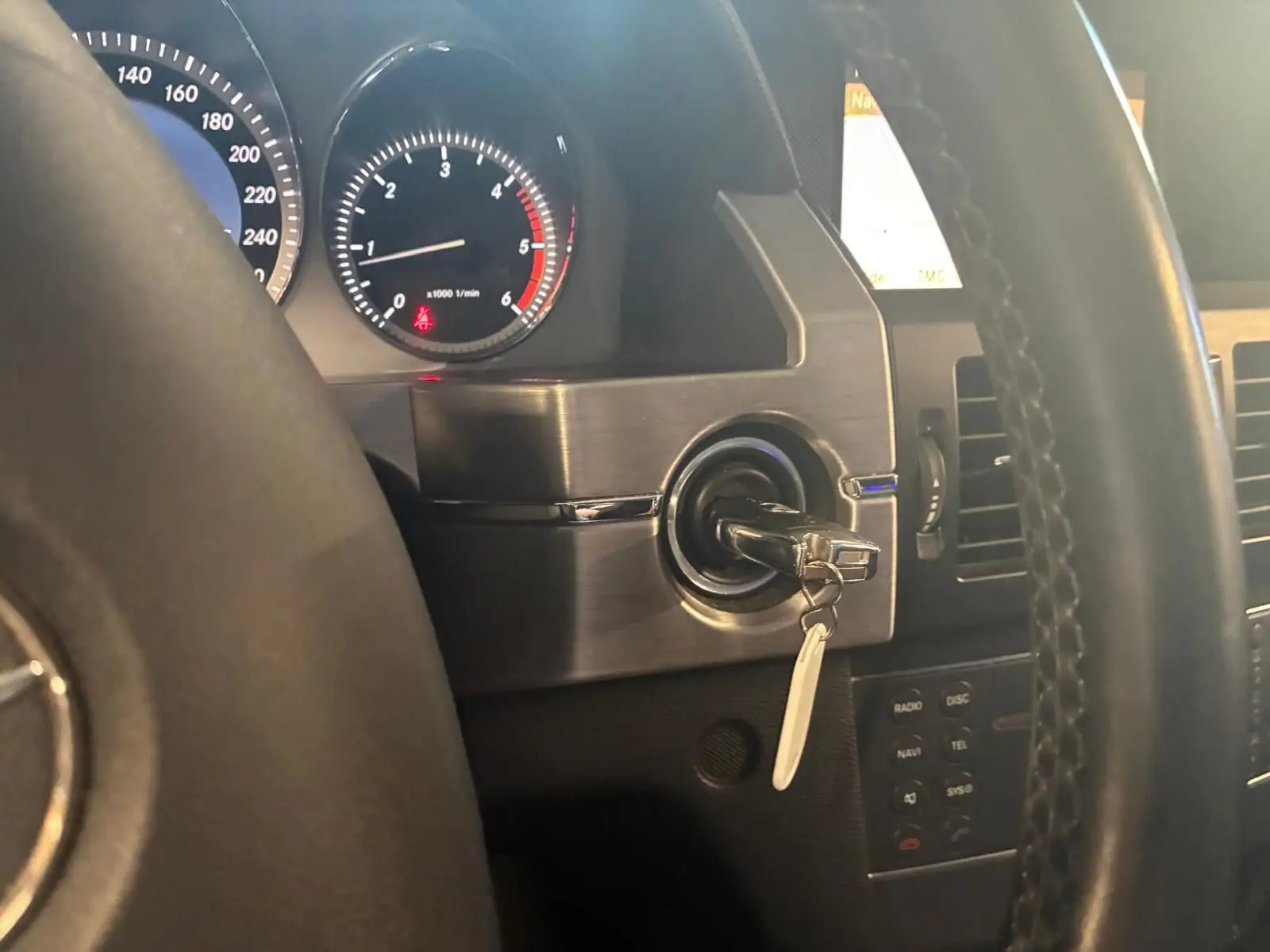 Vue intérieure rapprochée du tableau de bord noir du Mercedes GLK 220 CDI avec clé insérée dans le contacteur.