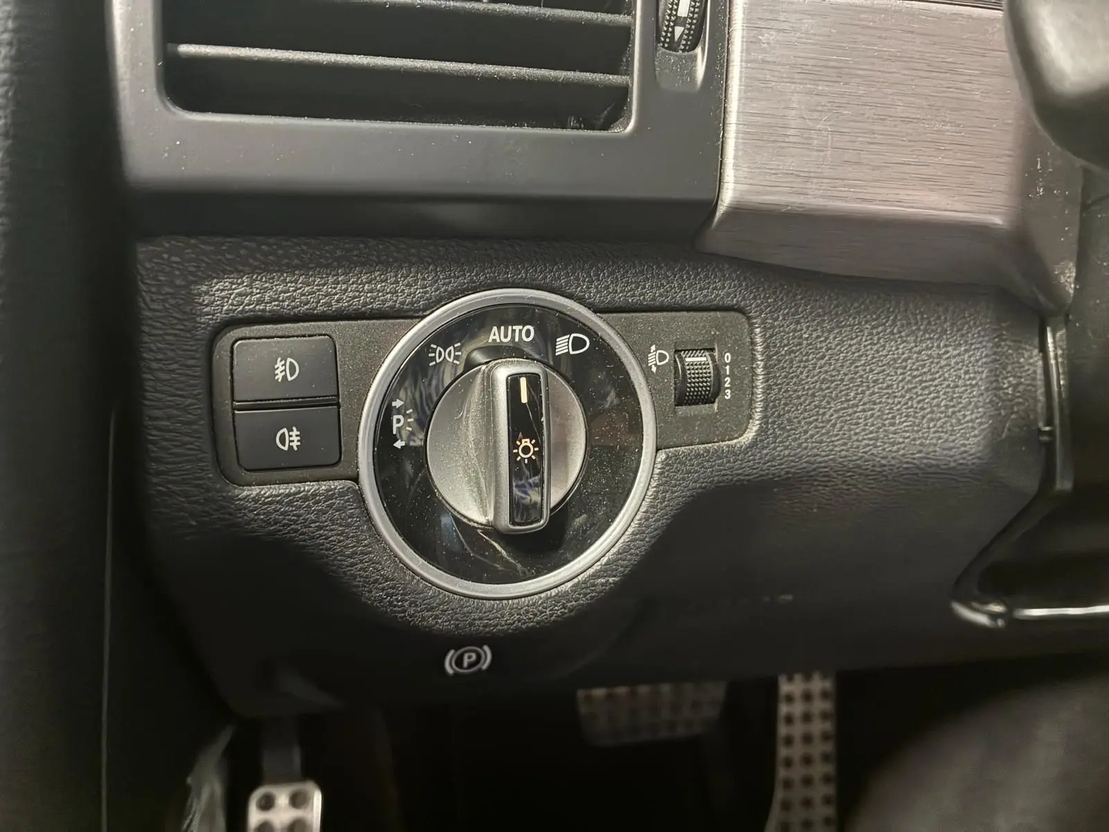Gros plan sur le bouton de commande des phares dans l’habitacle noir du Mercedes GLK 220 CDI Phase 2.