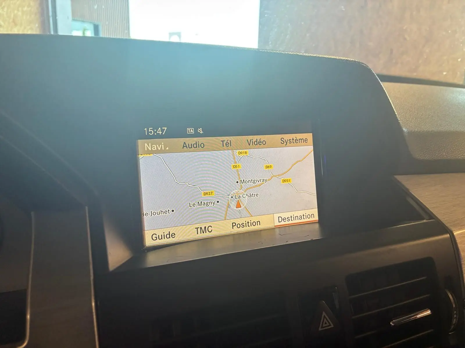 Écran de navigation GPS affichant une carte, situé sur le tableau de bord d’un Mercedes GLK noir, vue intérieure.