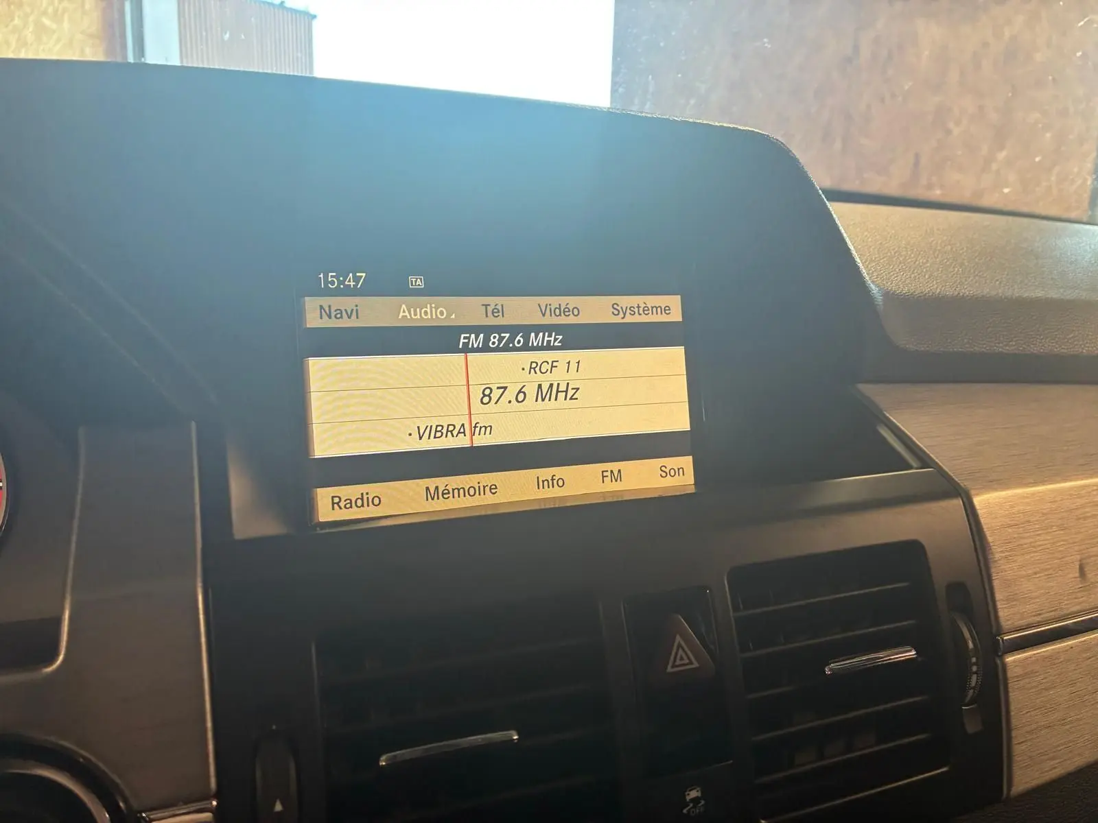 Écran central de la Mercedes GLK 220 CDI noir de 2012 affichant la radio FM avec commandes et aérateurs visibles.