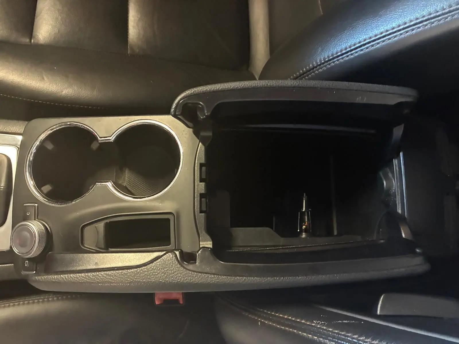 Vue rapprochée de la console centrale ouverte avec porte-gobelets, intérieur cuir noir du Mercedes GLK 220 CDI 2012.