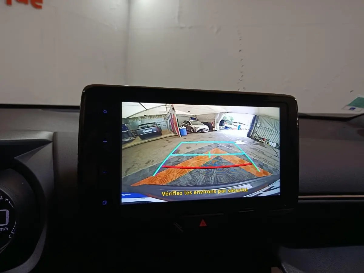 Écran tactile central montrant la caméra de recul avec guidage, intérieur noir du Toyota Yaris Cross gris foncé.