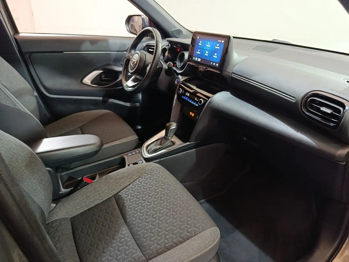 Vue intérieure côté conducteur de la Toyota Yaris Cross 2022, avec tableau de bord noir et écran tactile central.