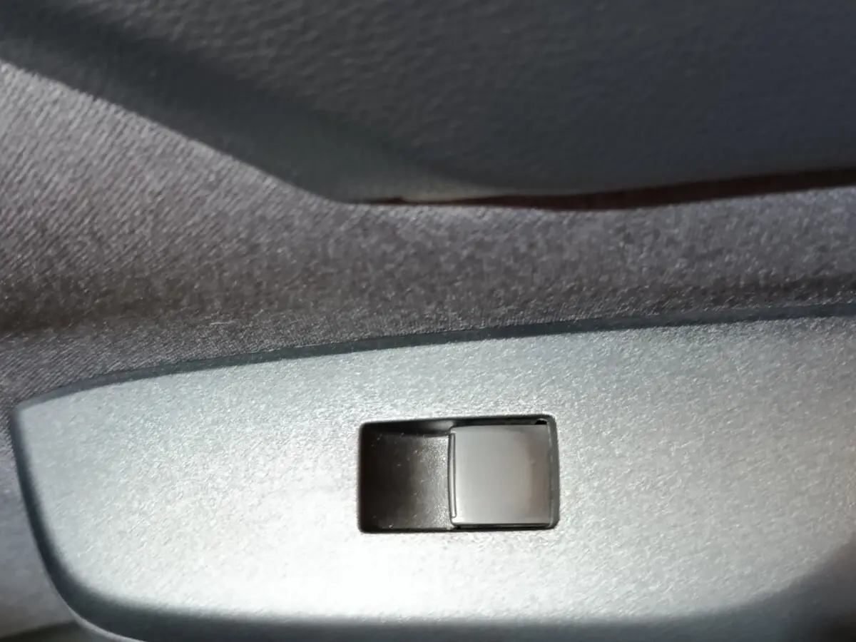 Gros plan sur l'interrupteur de lève-vitre côté porte intérieure d'une Toyota Yaris Cross gris foncé 2022.