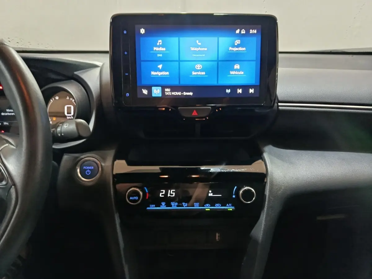 Vue intérieure centrée sur le tableau de bord et l’écran tactile de la Toyota Yaris Cross 2022 gris foncé.