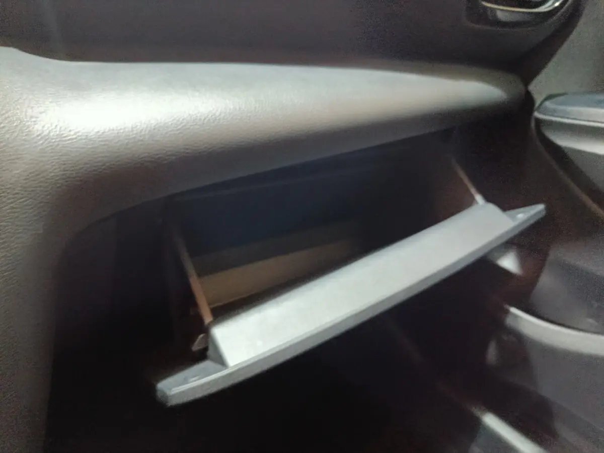 Gant de boîte à gants ouvert côté passager intérieur du Toyota Yaris Cross gris foncé 2022.