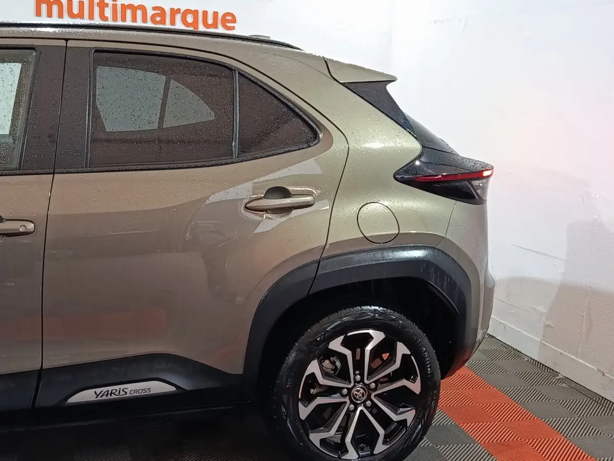 Vue côté droit arrière d’une Toyota Yaris Cross gris foncé avec jantes alliage et logo visible sur la porte arrière.