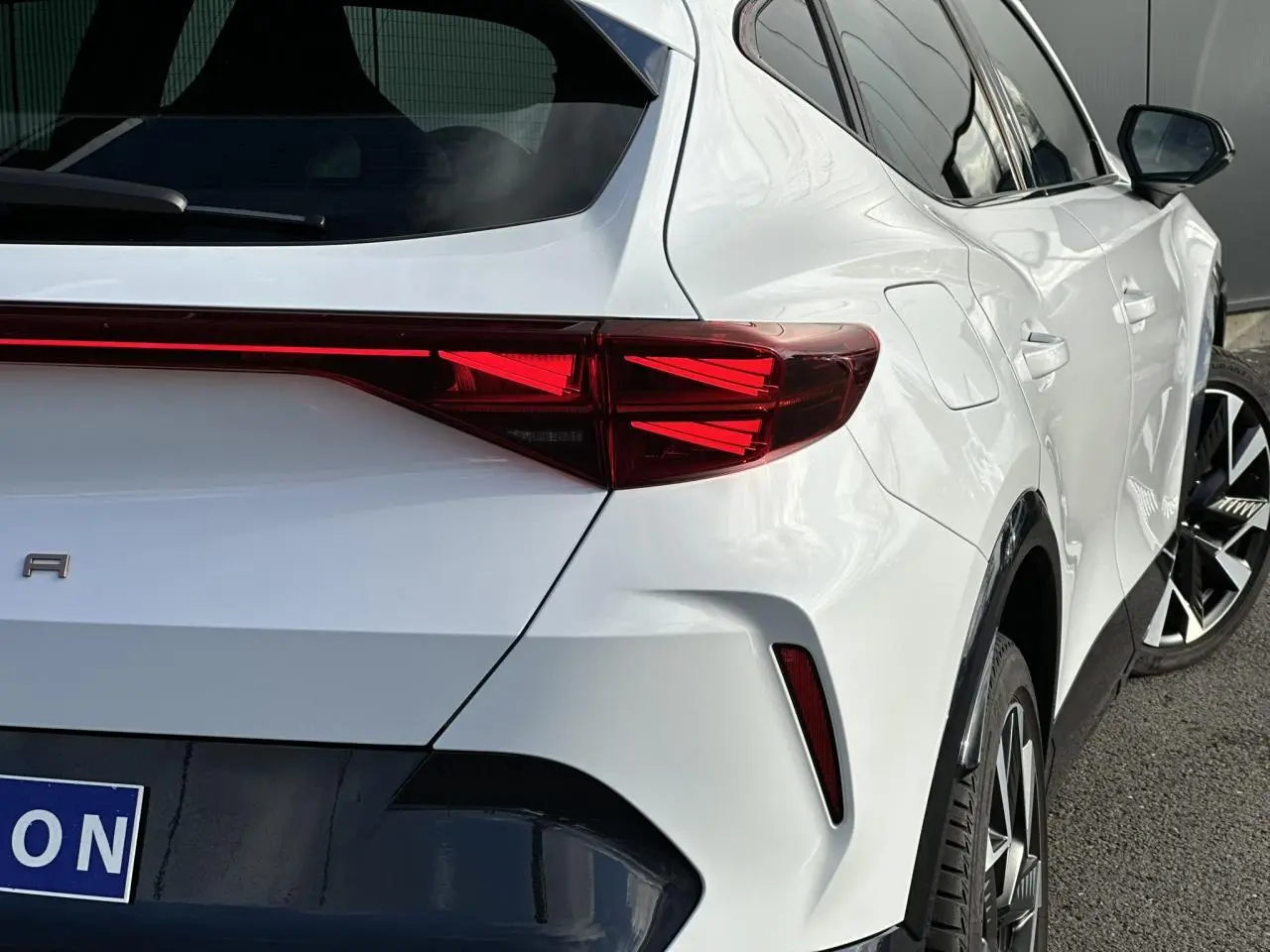 Vue 3/4 arrière droite d'une CUPRA Formentor blanc Neige avec feux arrière Tri-LED et jantes alliage 19 pouces Sandstorm.