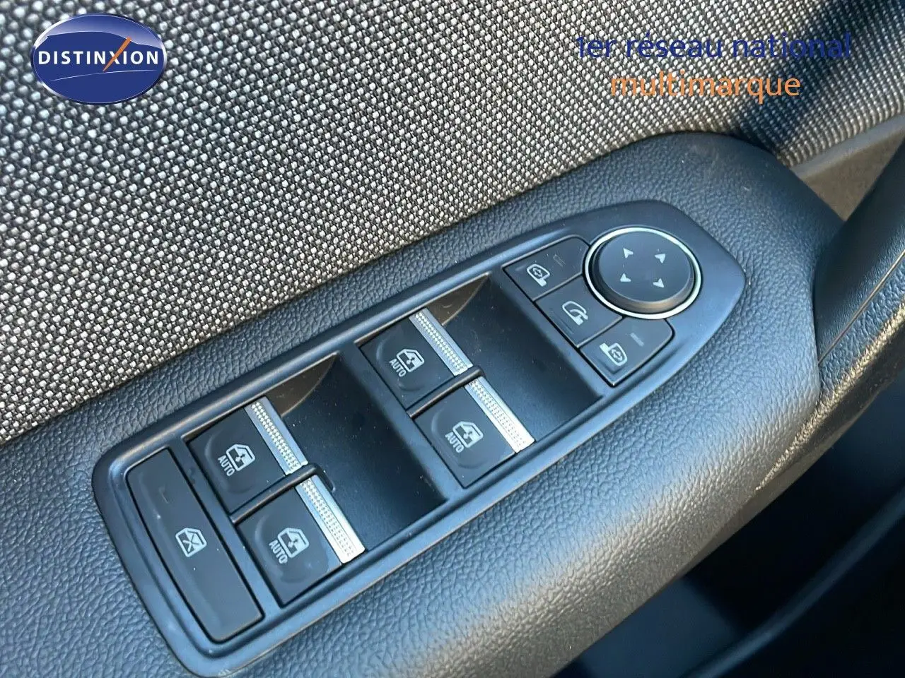 Commande des vitres électriques et réglage des rétroviseurs sur la porte côté gauche d'un Renault Captur bleu Iron Metal toit noir.