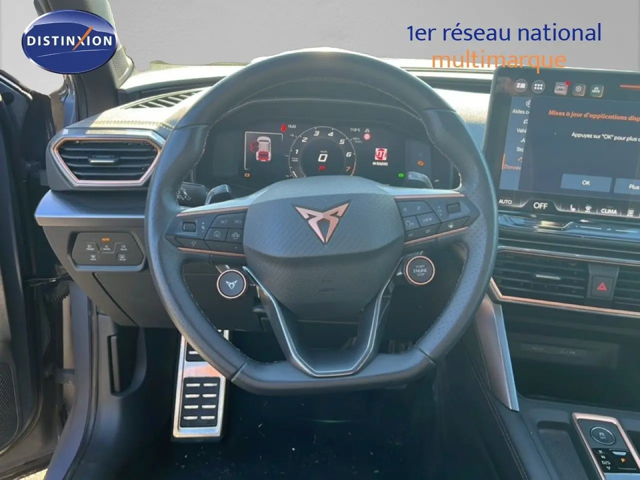 Vue intérieure centrée sur le volant et tableau de bord du CUPRA Formentor 1.5 eTSI 2025 en gris Graphene, avec écran tactile visible.