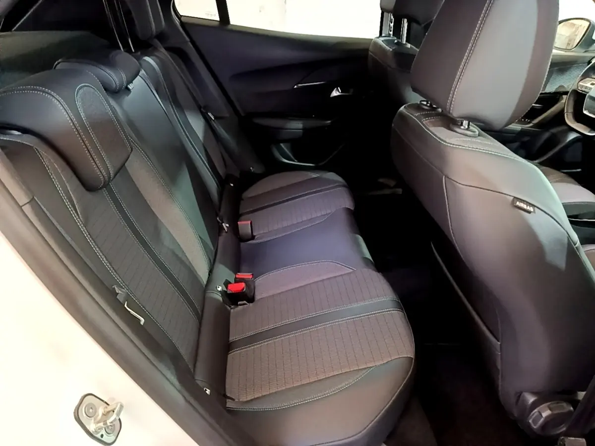 Vue intérieure côté gauche sur la banquette arrière noire du Peugeot 2008 blanc, avec appuie-têtes et ceintures visibles.