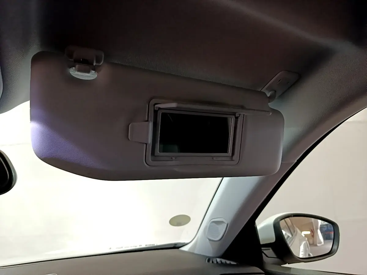 Pare-soleil côté conducteur avec miroir intégré, intérieur clair du Peugeot 2008 blanc vue depuis l'habitacle.