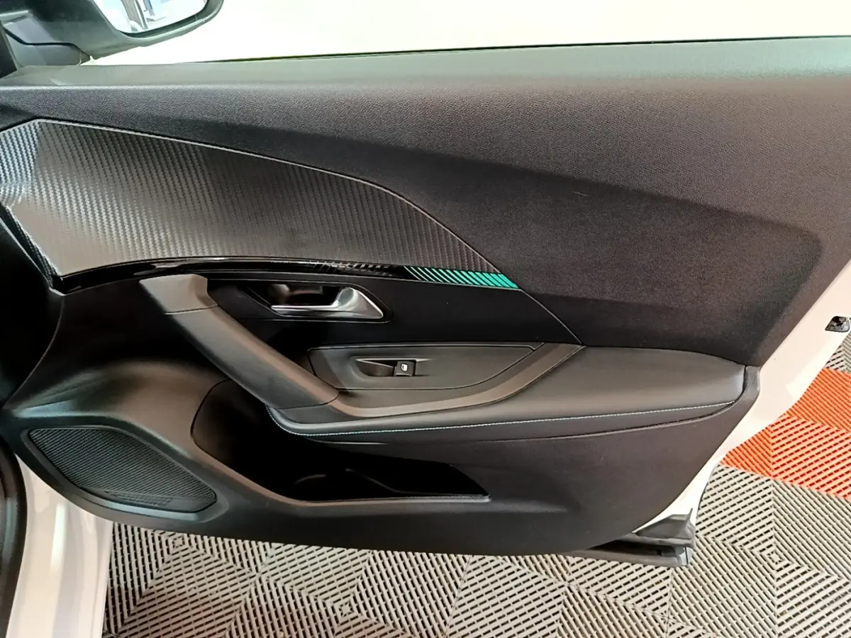 Vue intérieure côté gauche de la porte avant blanche du Peugeot 2008 avec insert décoratif et commande de vitre.