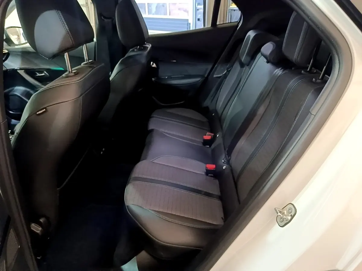 Vue intérieure côté droit montrant la banquette arrière noire et grise du Peugeot 2008 blanc, version BlueHDi 130 Allure Pack.